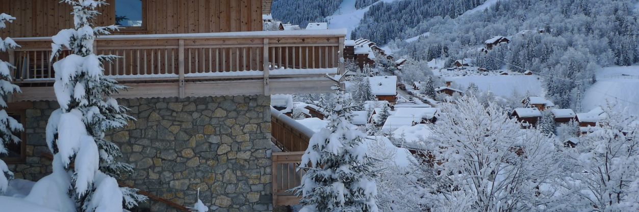 Exterior of a luxury chalet and view across the valley